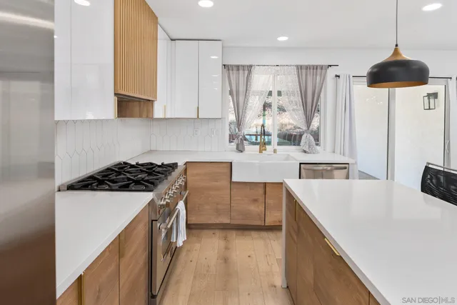 a kitchen with stainless steel appliances a stove a sink a refrigerator and cabinets
