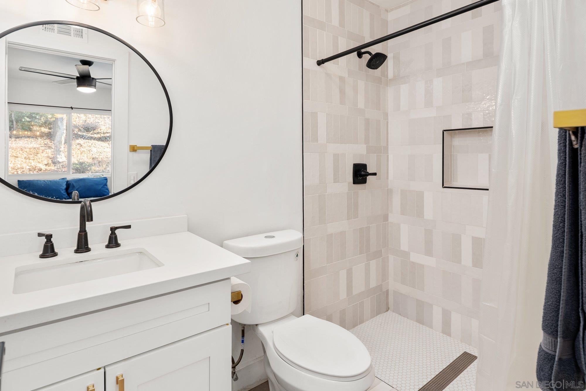 7942 Calico Street San Diego, CA 92126 - Photo 18 of 39 a bathroom with a sink a toilet and shower