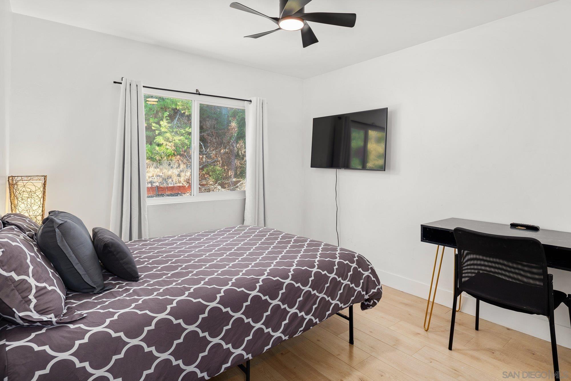 7942 Calico Street San Diego, CA 92126 - Photo 19 of 39 a bedroom with a bed and a flat screen tv