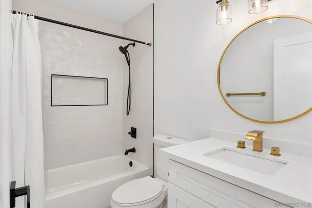 a bathroom with a sink a toilet and a mirror