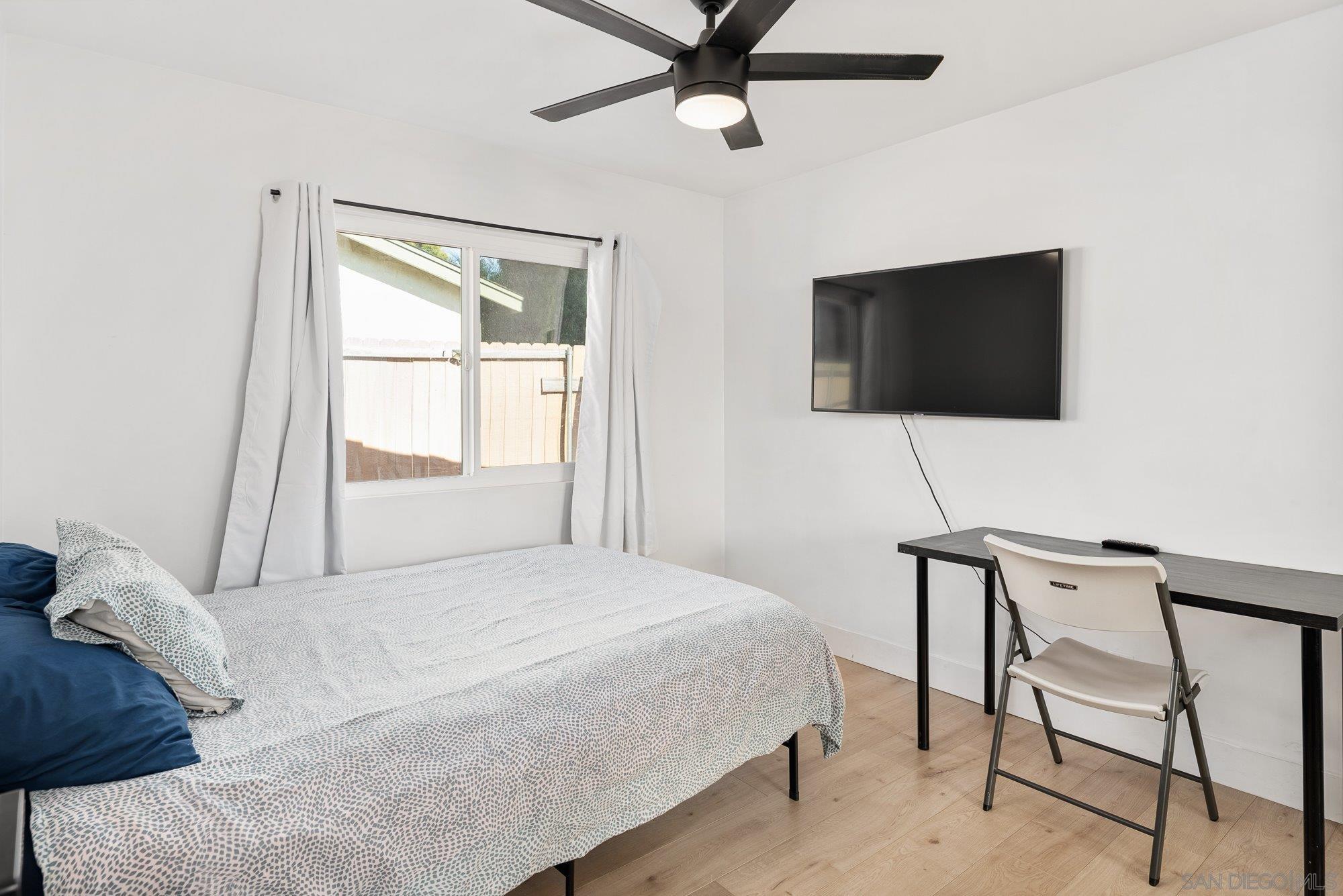 7942 Calico Street San Diego, CA 92126 - Photo 22 of 39 a bedroom with a bed and a flat screen tv