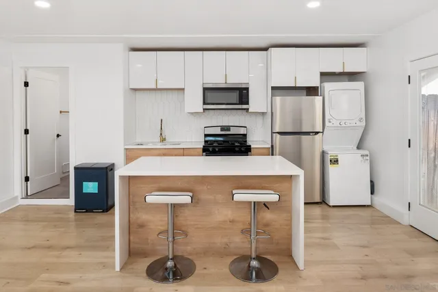 a kitchen with stainless steel appliances granite countertop a refrigerator a stove a microwave and white cabinets