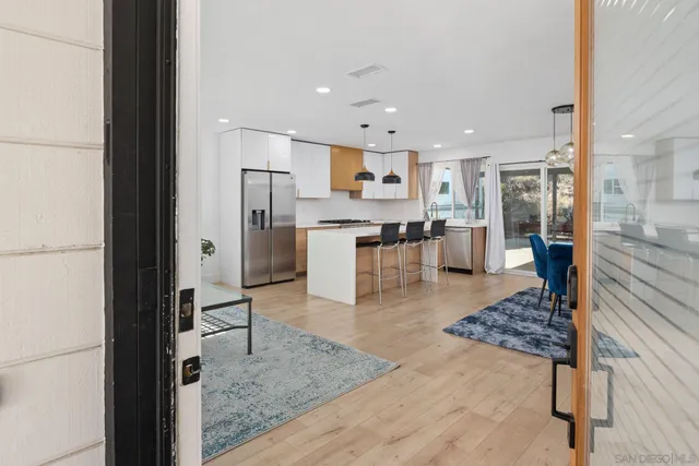 a kitchen with stainless steel appliances granite countertop a refrigerator oven a sink and white cabinets