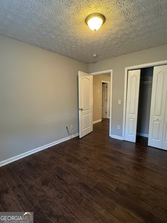 an empty room with wooden floor and closet