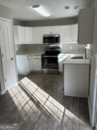 a kitchen with kitchen island granite countertop a sink and steel appliances