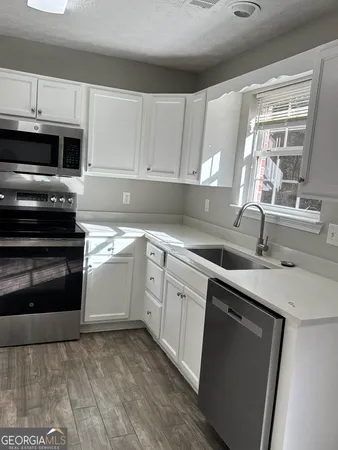 a kitchen with granite countertop a sink and cabinets