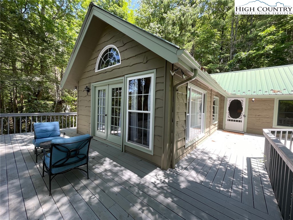 a front view of a house with yard outdoor seating and covered with trees