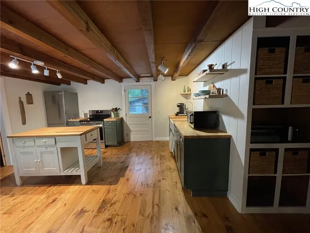 a living room with stainless steel appliances kitchen island granite countertop a sink and cabinets
