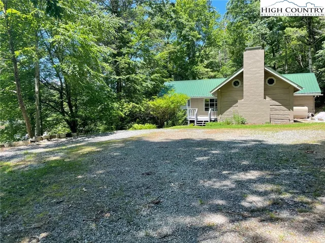 a view of a house with a yard and sitting area