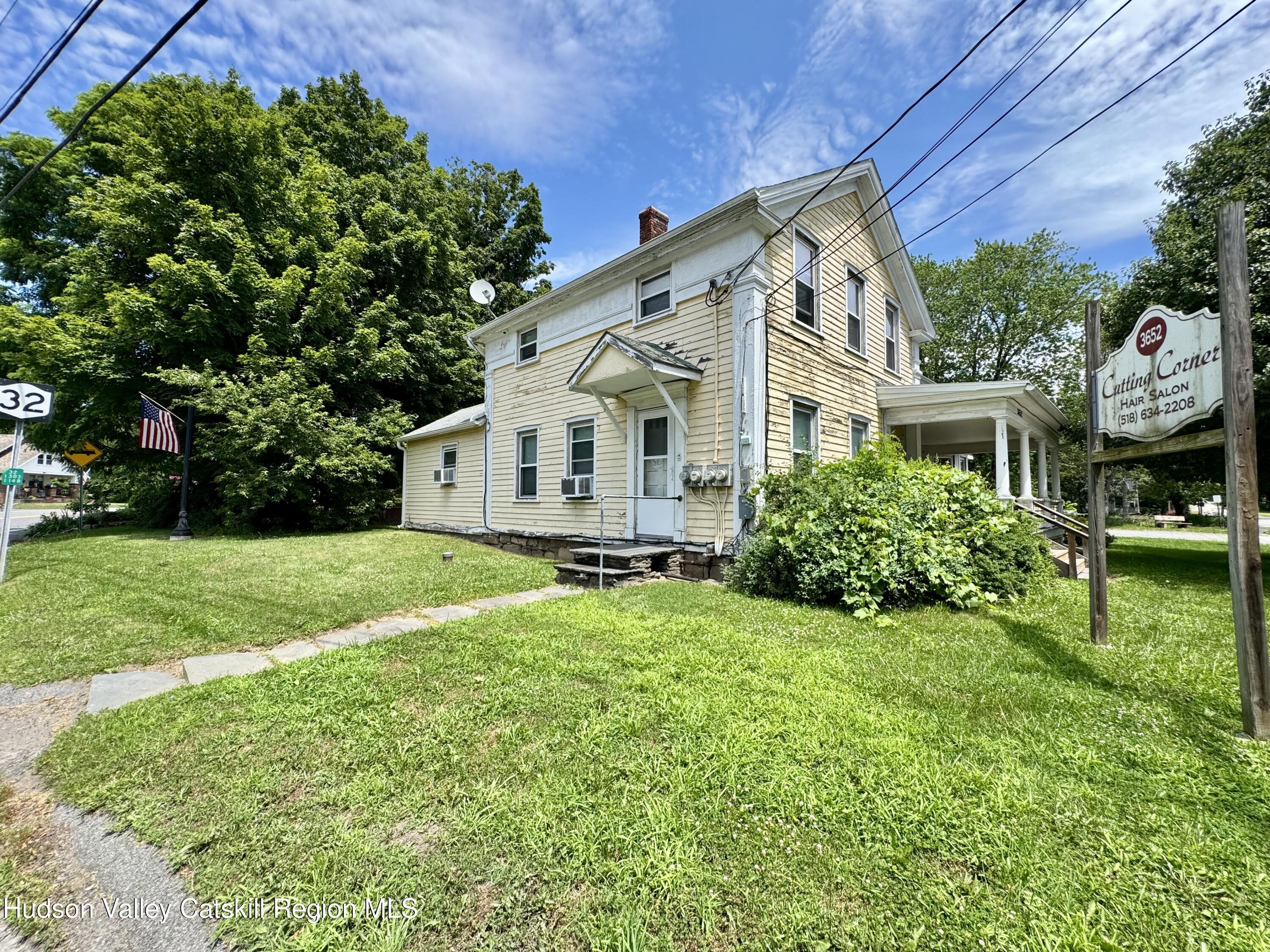 a front view of a house with yard and green space