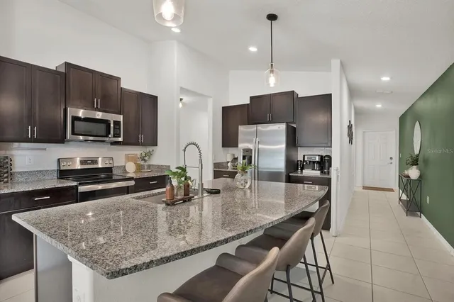 a kitchen with stainless steel appliances granite countertop a sink refrigerator and microwave