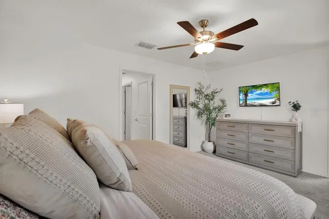 a bed room with a bed and a ceiling fan