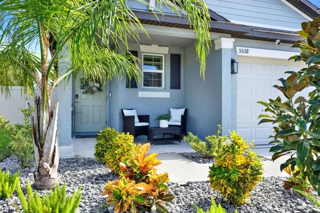 a couple of flower plants in front of a house