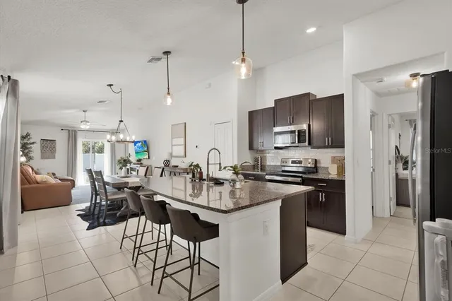 a kitchen with refrigerator cabinets dining table and chairs