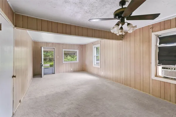 a view of a livingroom with a ceiling fan and window