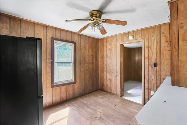 a view of a hallway with a chandelier fan and windows