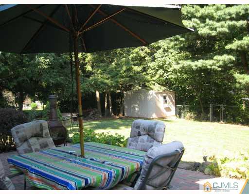 3 Kyle Road Somerset, NJ 08873 - Photo 10 of 10 a view of a backyard with couches table and chairs under an umbrella