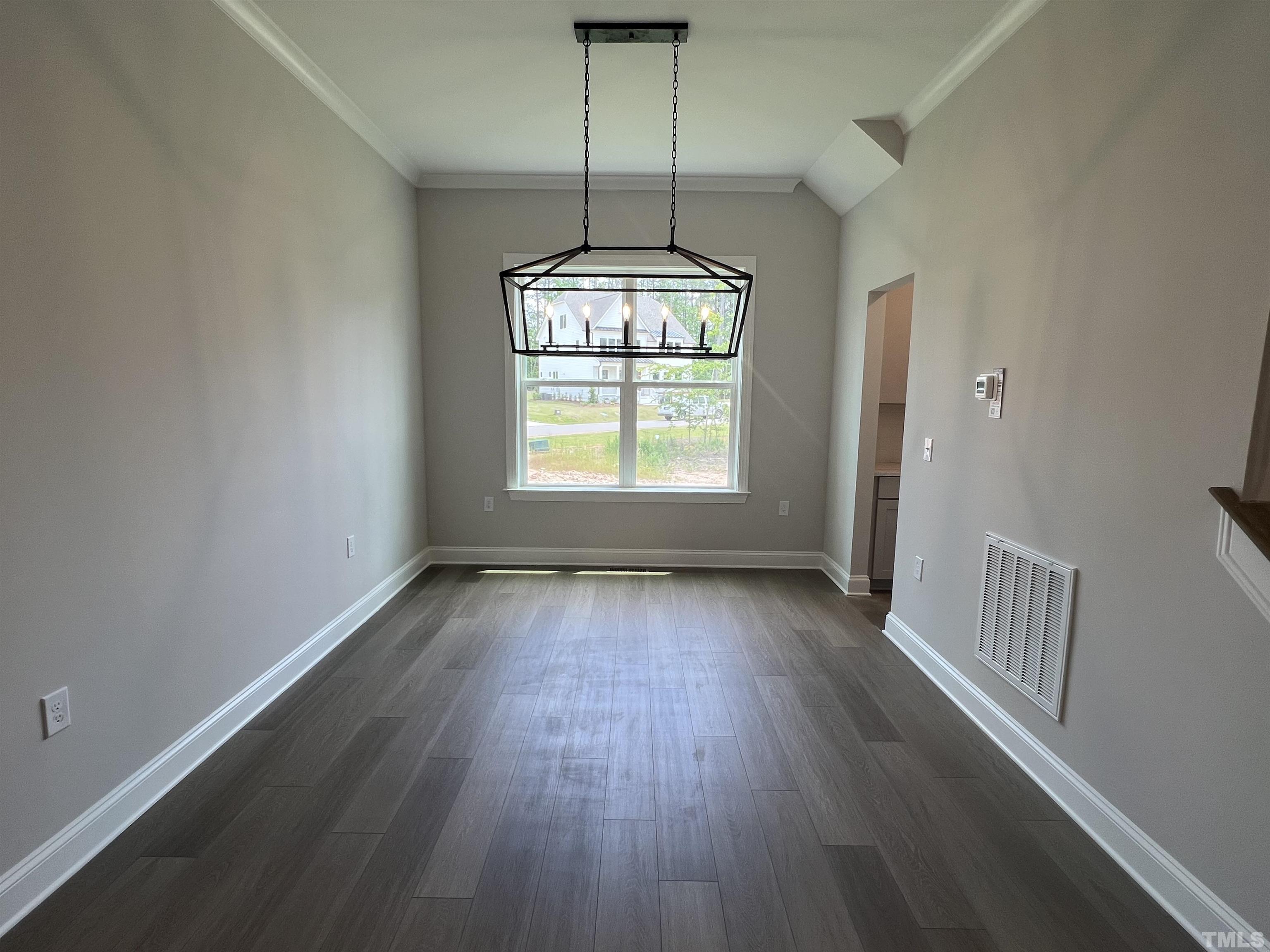 7629 Hasentree Way, Unit 519 Wake Forest, NC 27587 - Photo 13 of 76 an empty room with wooden floor chandelier and windows