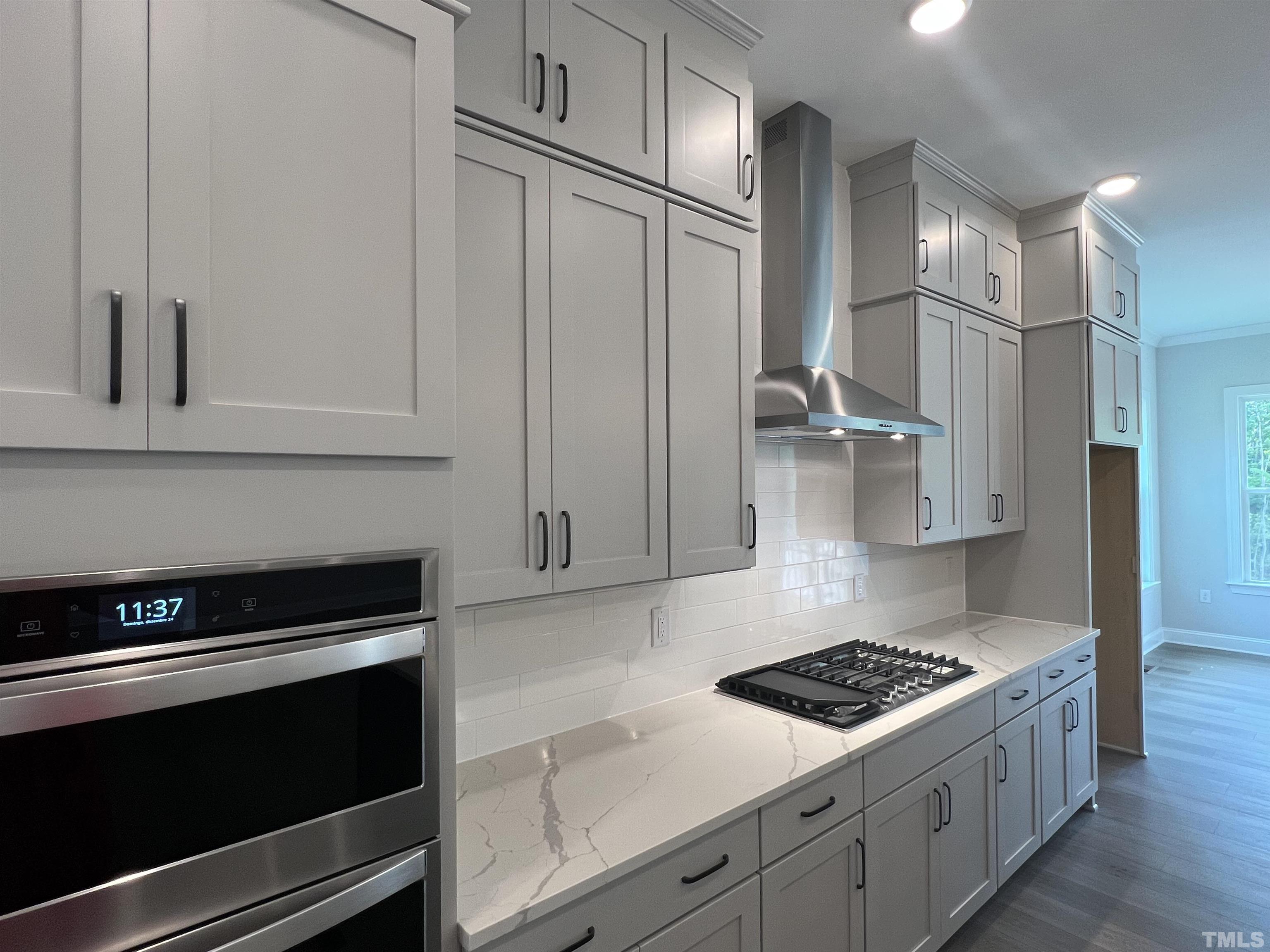 7629 Hasentree Way, Unit 519 Wake Forest, NC 27587 - Photo 18 of 76 a kitchen with stainless steel appliances granite countertop a stove and a refrigerator with white cabinets