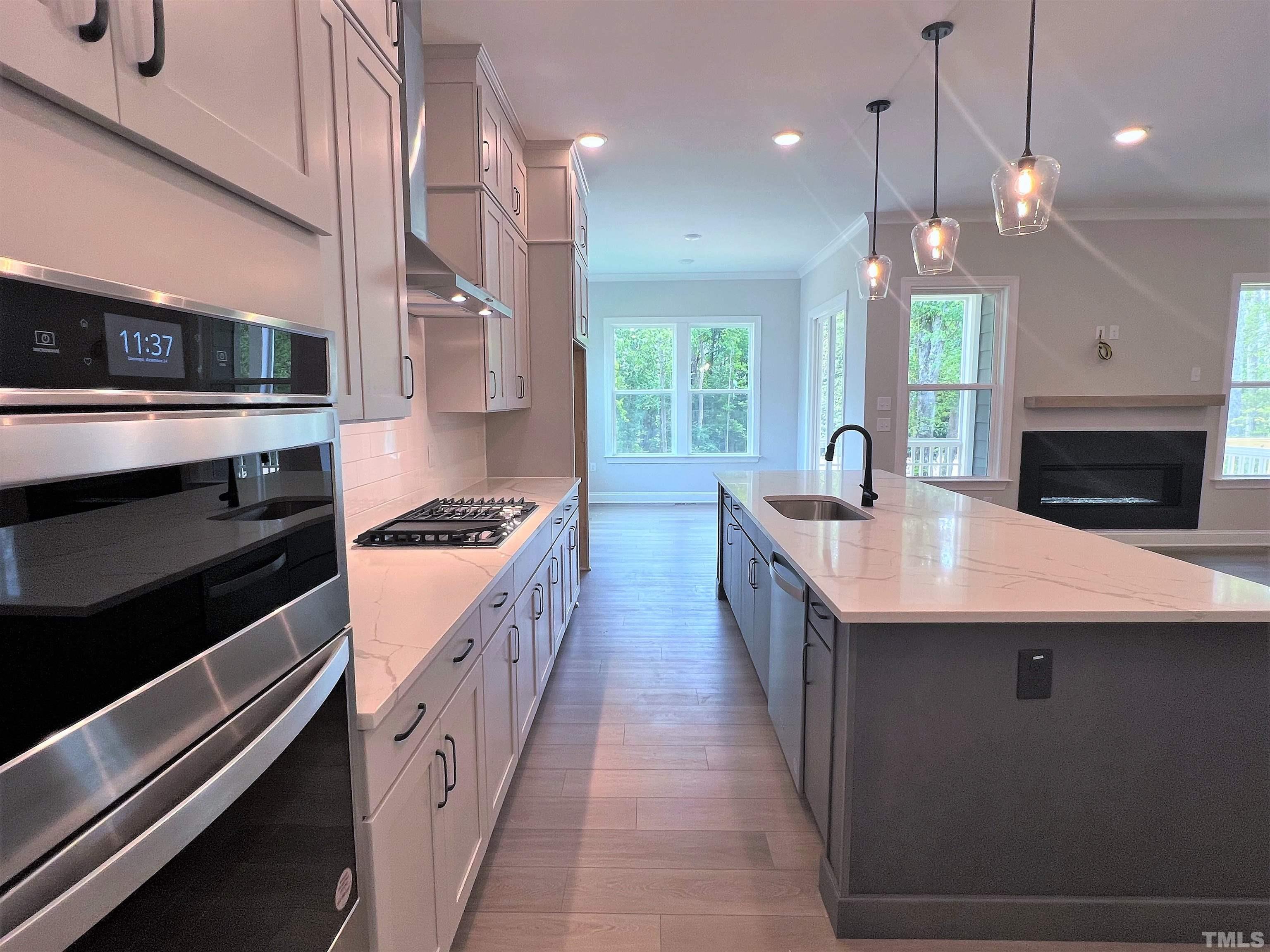 7629 Hasentree Way, Unit 519 Wake Forest, NC 27587 - Photo 19 of 76 a large kitchen with a large counter top a sink stainless steel appliances and cabinets