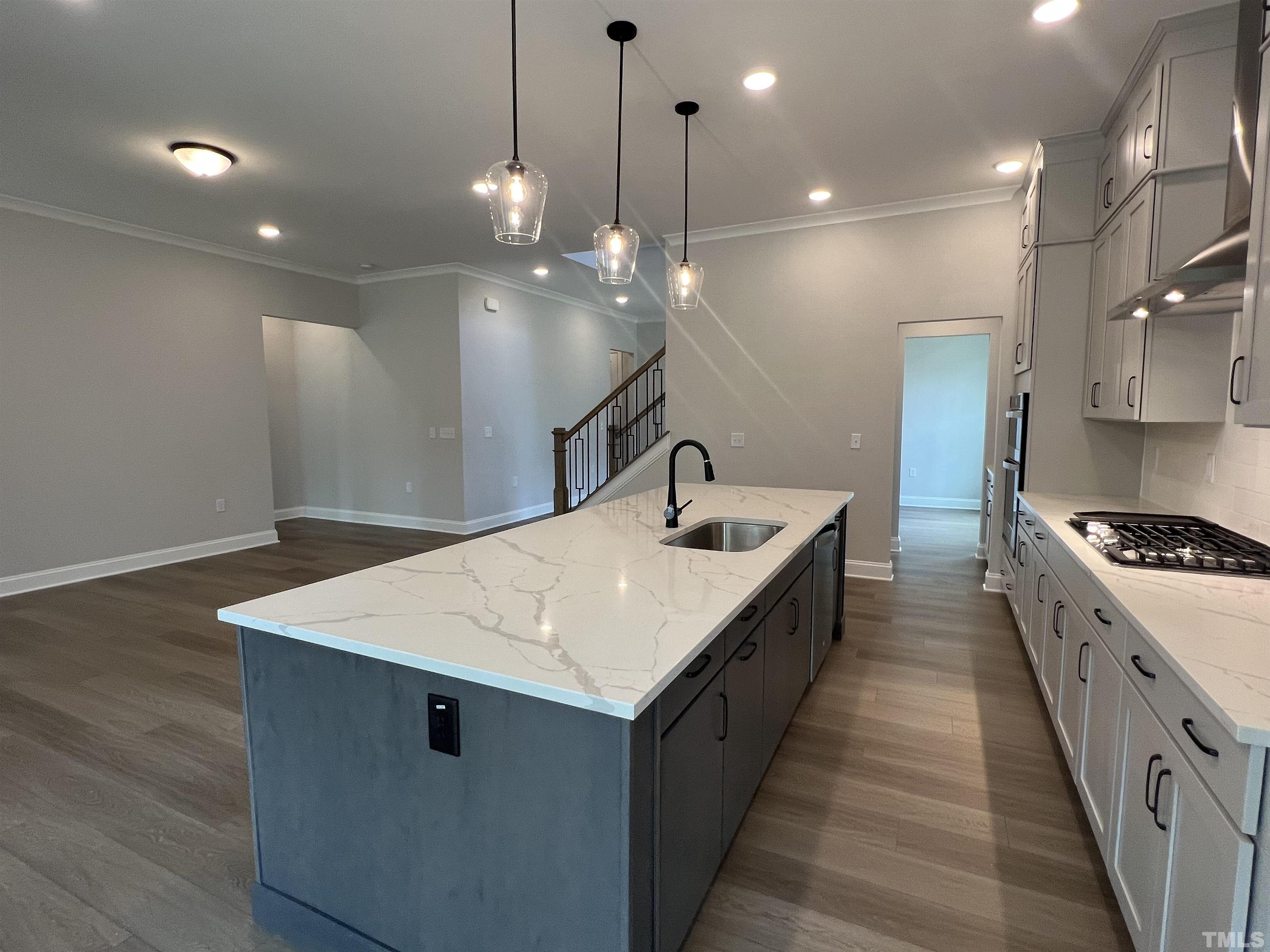 7629 Hasentree Way, Unit 519 Wake Forest, NC 27587 - Photo 20 of 76 a kitchen with kitchen island a sink appliances and wooden floor