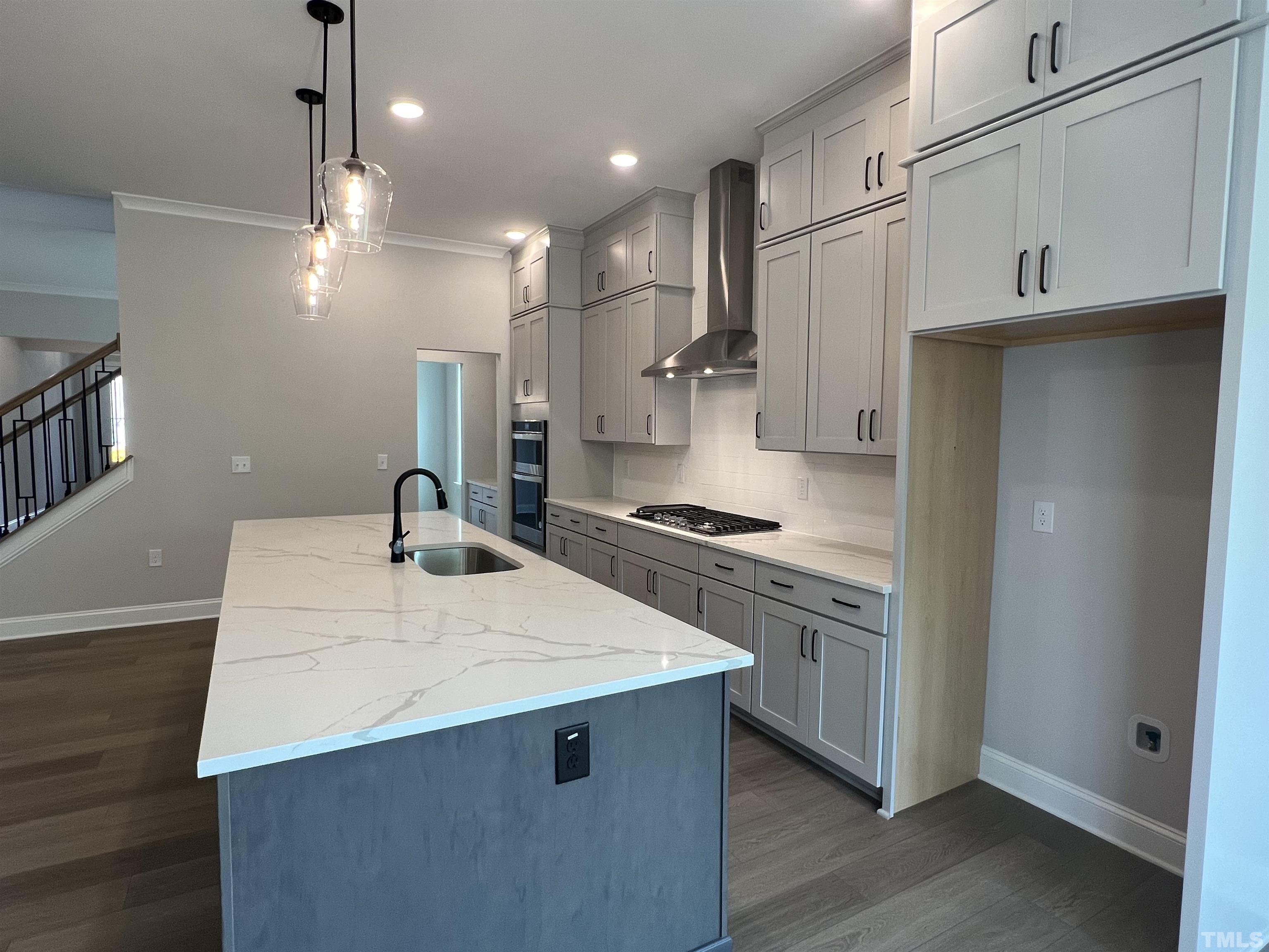 7629 Hasentree Way, Unit 519 Wake Forest, NC 27587 - Photo 21 of 76 a kitchen with kitchen island a sink stainless steel appliances and cabinets