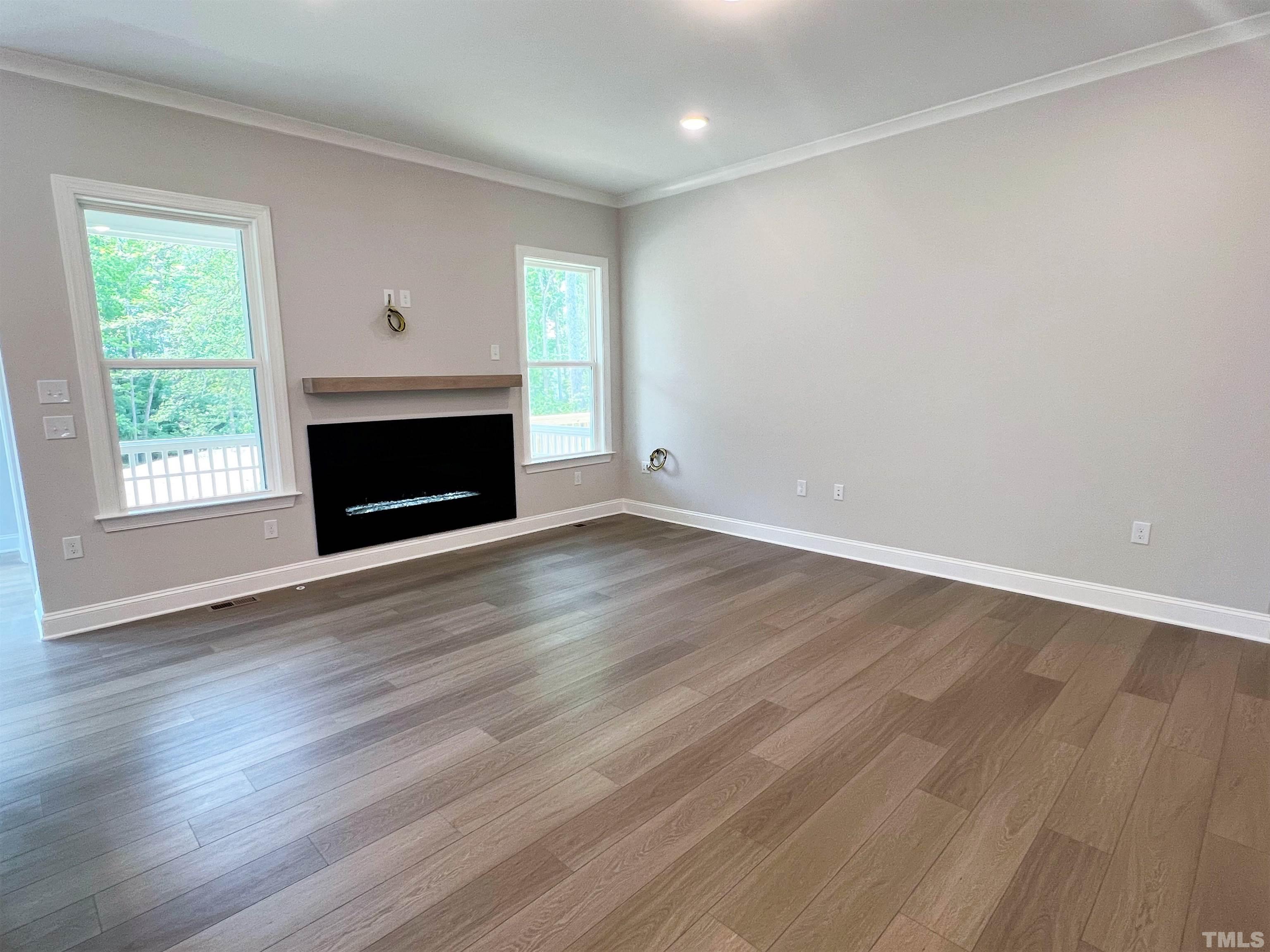 7629 Hasentree Way, Unit 519 Wake Forest, NC 27587 - Photo 27 of 76 an empty room with wooden floor fireplace and windows