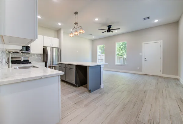 a kitchen with kitchen island a sink stainless steel appliances and window