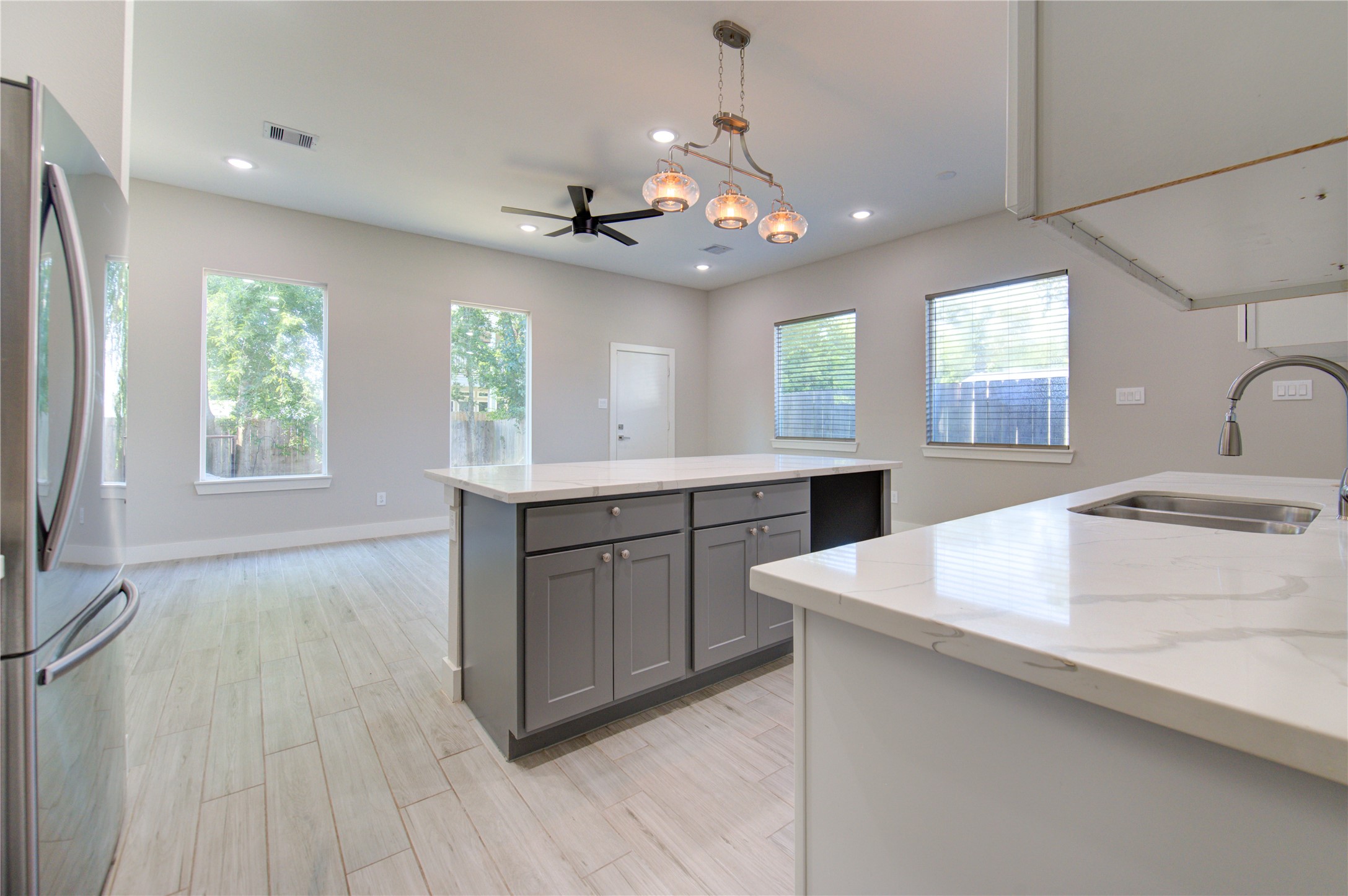 4536 Sunflower Street Houston, TX 77051 - Photo 6 of 27 a kitchen with a sink a chandelier stainless steel appliances cabinets and a window
