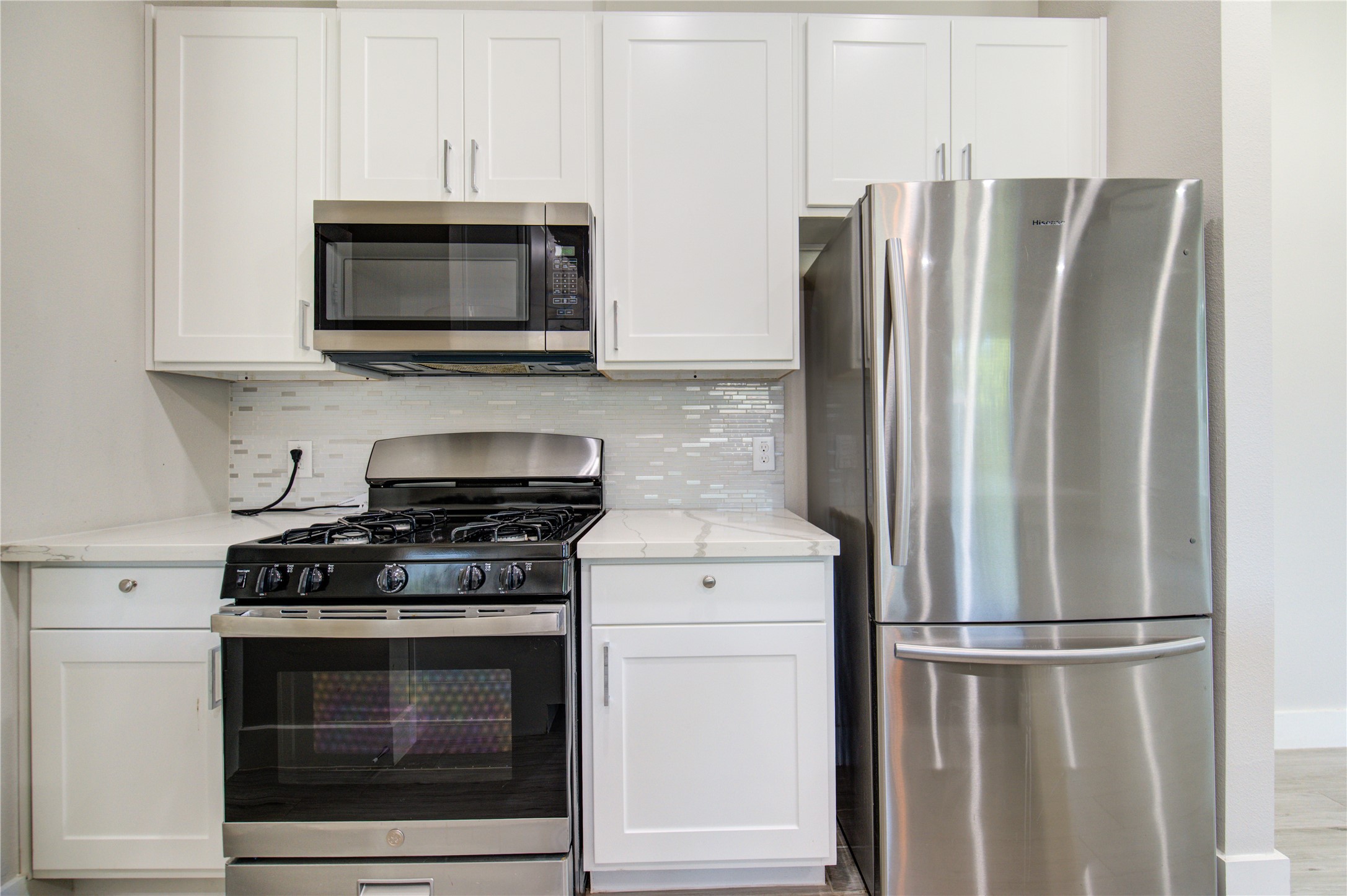 4536 Sunflower Street Houston, TX 77051 - Photo 7 of 27 a kitchen with stainless steel appliances white cabinets white stove a microwave and a refrigerator
