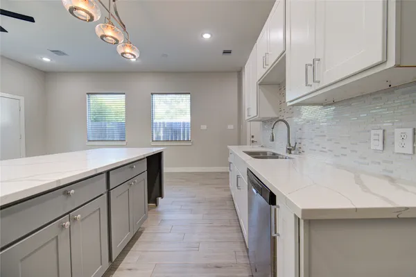a kitchen with sink a microwave and cabinets