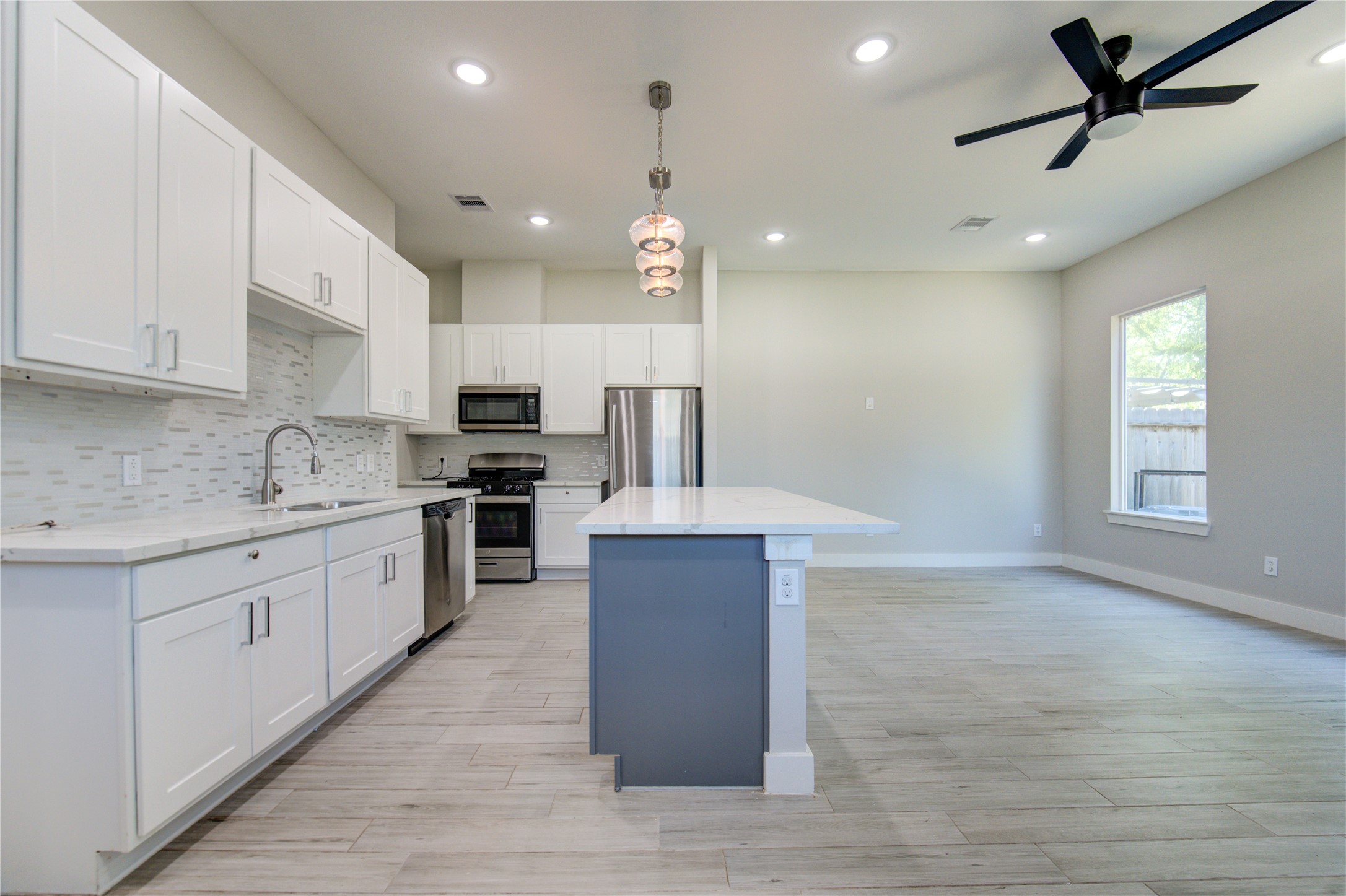 4536 Sunflower Street Houston, TX 77051 - Photo 10 of 27 a large kitchen with stainless steel appliances kitchen island granite countertop a stove a sink and a refrigerator