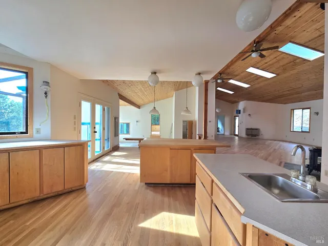 a large kitchen with stainless steel appliances granite countertop a lot of counter space and wooden floors