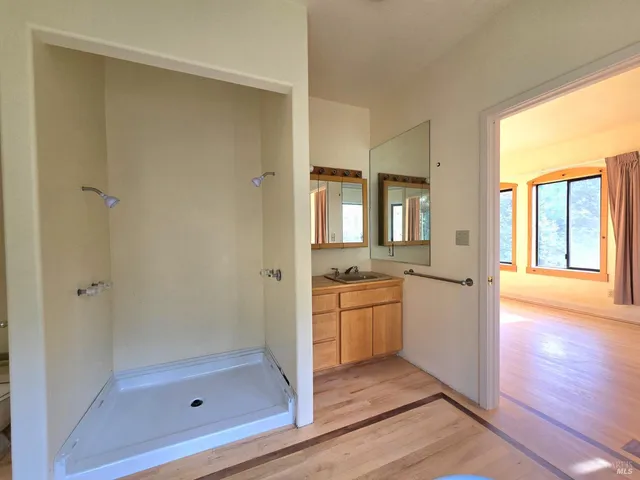 a bathroom with a granite countertop sink a mirror and a bathtub