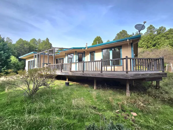 a view of a house with backyard and sitting area
