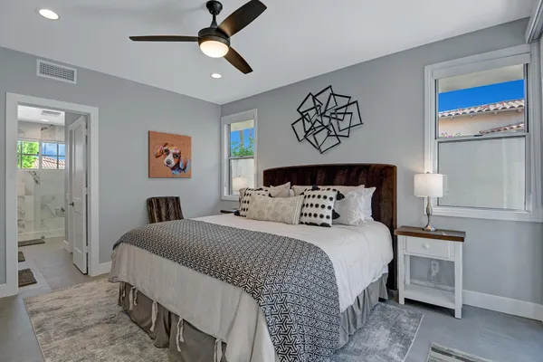 a bedroom with a bed a television and a large window