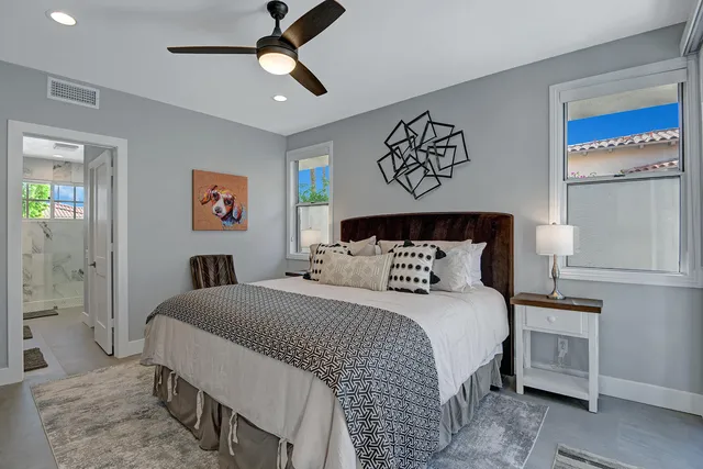 a bedroom with a bed a television and a large window