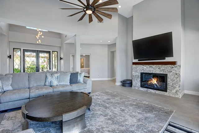 a living room with furniture a flat screen tv and a fireplace