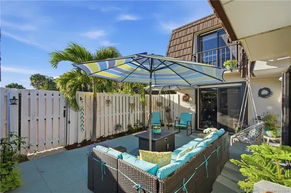 a view of patio with a table and chairs under an umbrella