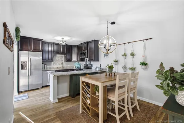a kitchen with granite countertop wooden cabinets stainless steel appliances and a sink