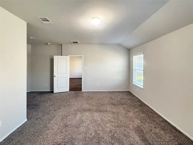 an empty room with windows and cabinet