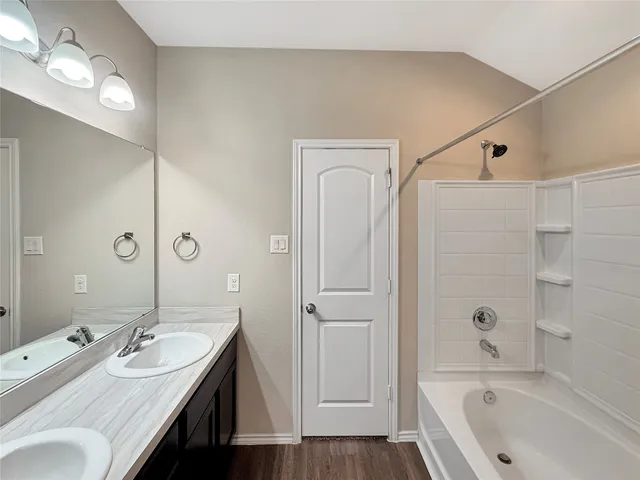 a bathroom with a tub a sink and a mirror