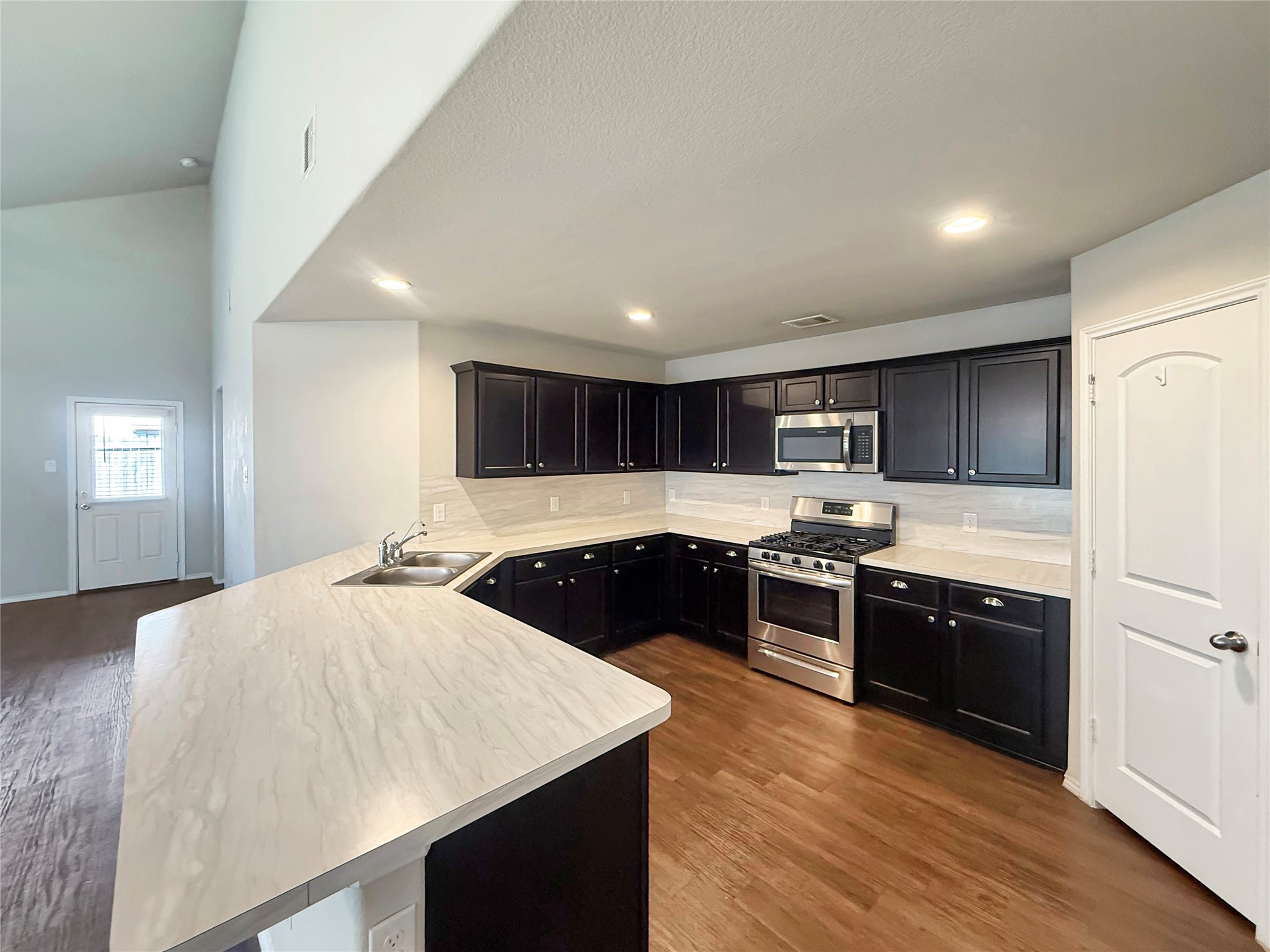 15443 Cipres Verde Street Channelview, TX 77530 - Photo 8 of 27 a large kitchen with kitchen island a sink stainless steel appliances and cabinets