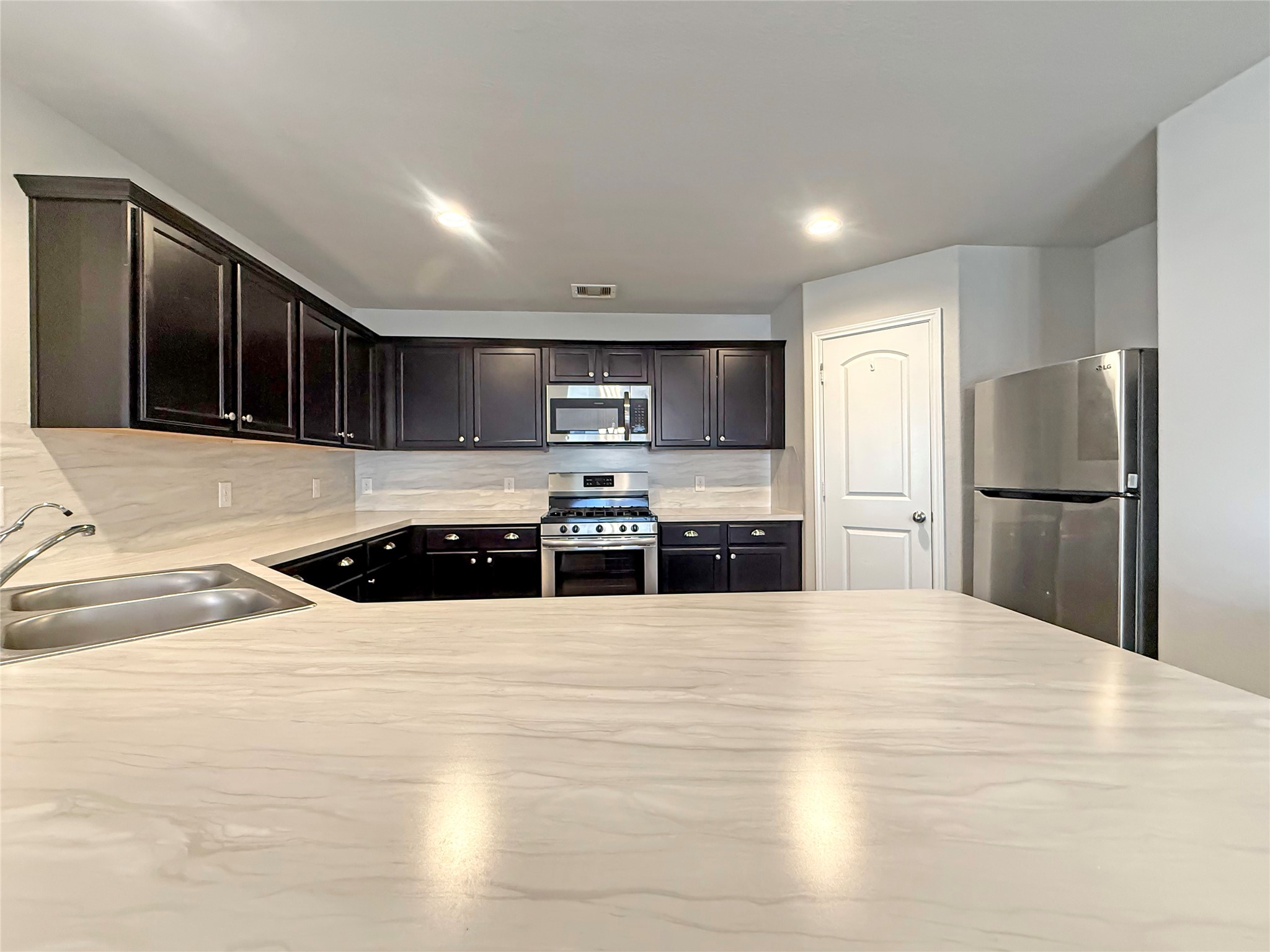 15443 Cipres Verde Street Channelview, TX 77530 - Photo 10 of 27 a large kitchen with a stove a refrigerator and a sink