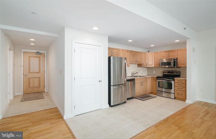901 North Penn Street, Unit R903 Philadelphia, PA 19123 - Photo 5 of 18 a kitchen with refrigerator cabinets and microwave