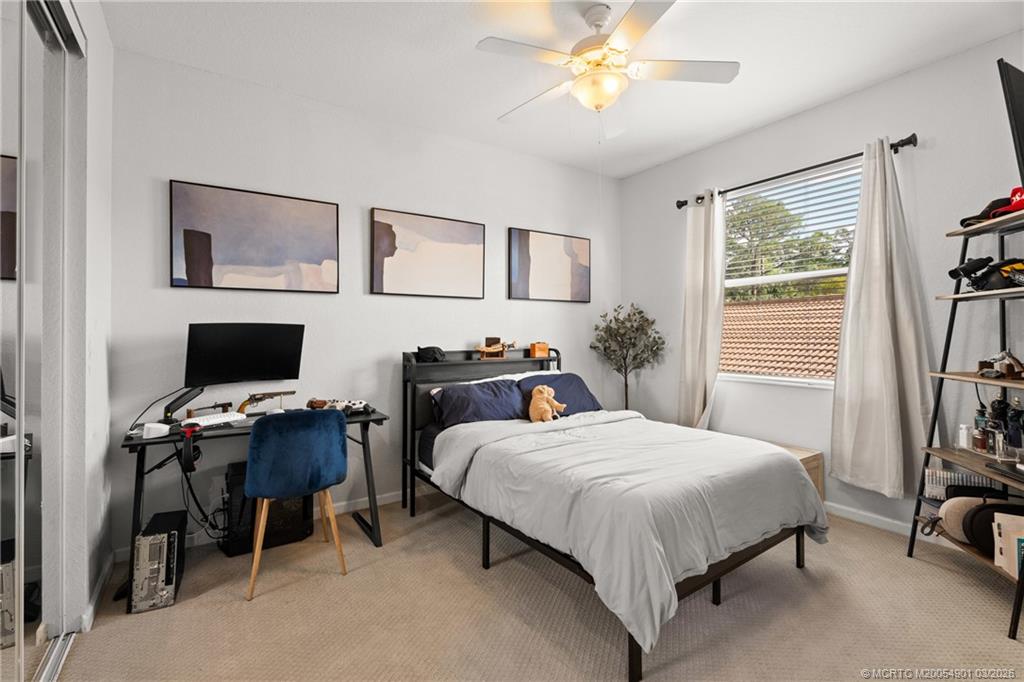 2973 Southwest Porpoise Circle Stuart, FL 34997 - Photo 21 of 47 a bedroom with a bed and a desk