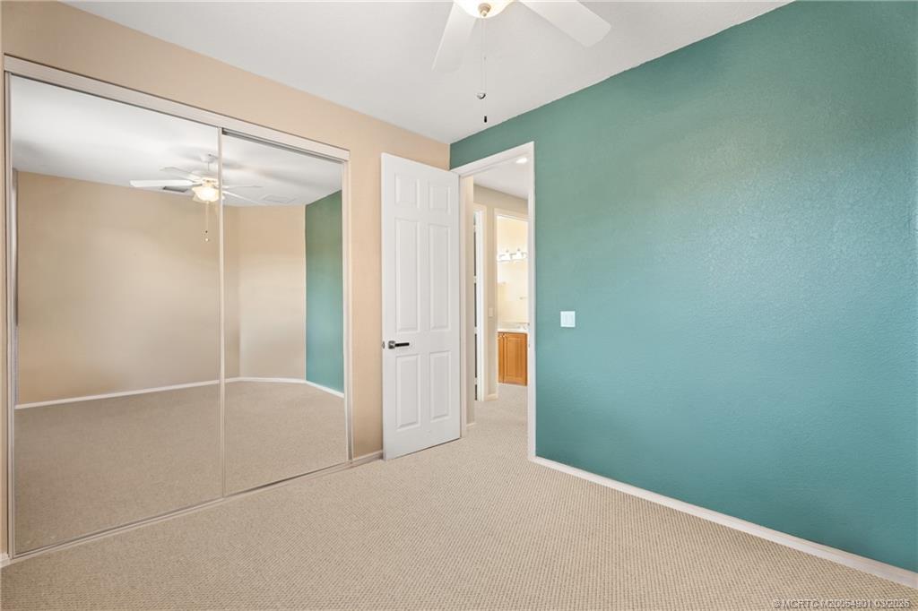 2973 Southwest Porpoise Circle Stuart, FL 34997 - Photo 22 of 47 an empty room with closet and a chandelier fan