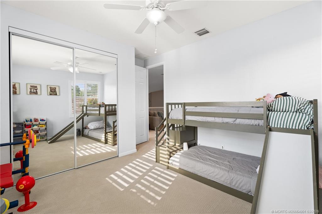 2973 Southwest Porpoise Circle Stuart, FL 34997 - Photo 27 of 47 a bedroom with furniture and a chandelier