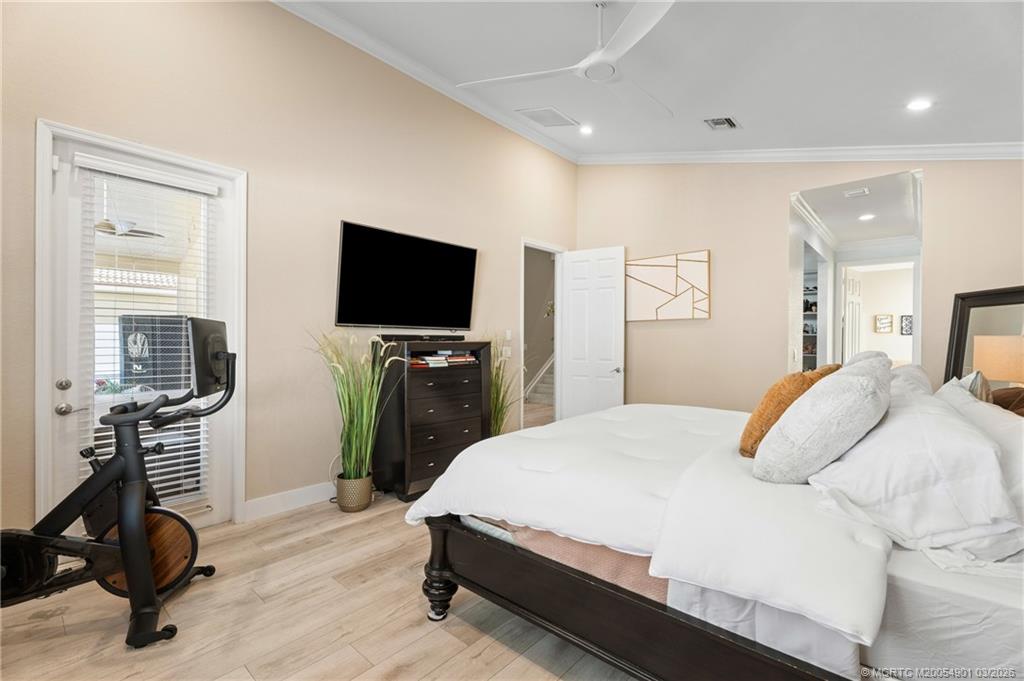 2973 Southwest Porpoise Circle Stuart, FL 34997 - Photo 29 of 47 a bedroom with a bed a television and a large window