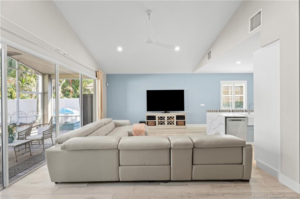 2973 Southwest Porpoise Circle Stuart, FL 34997 - Photo 31 of 47 a bedroom with a bed a large window and a flat screen television